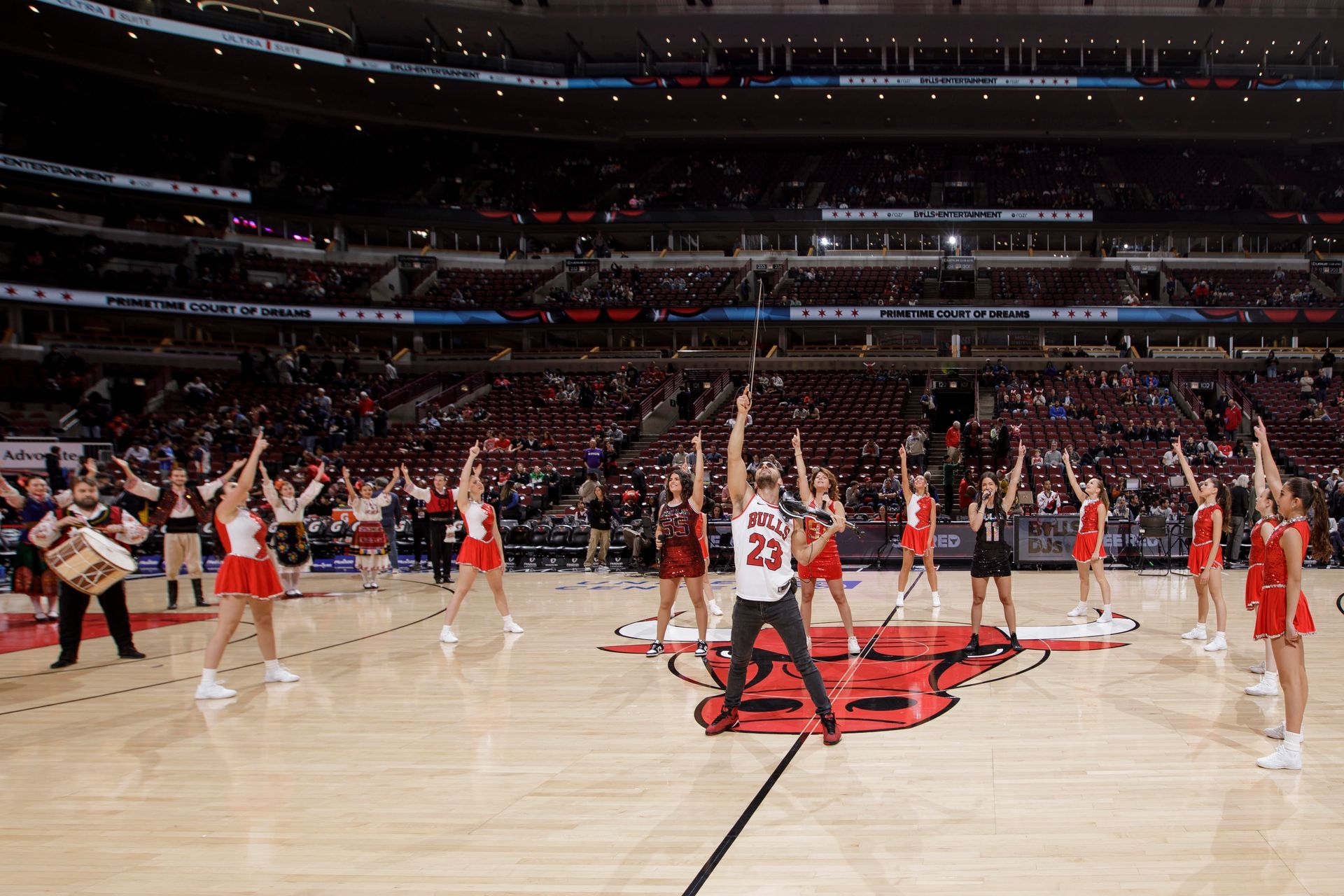 Three women singing into microphones on stage.
