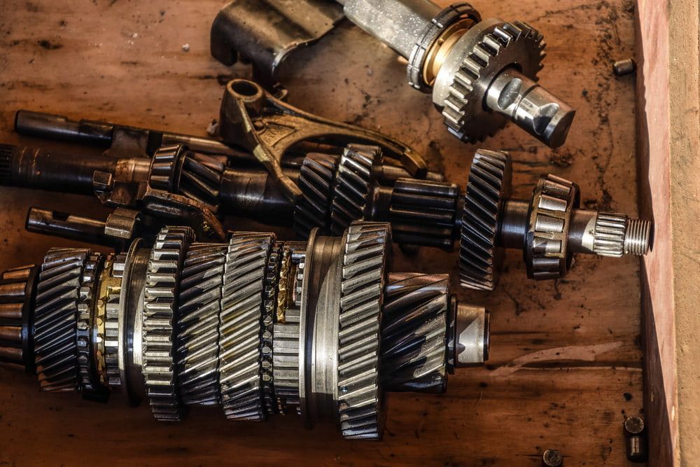A Bunch Of Gears Are Sitting On A Wooden Table — Evco Automotive in South Albury, NSW