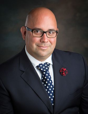 Attorney MacLachlan in a suit and tie is smiling for the camera.