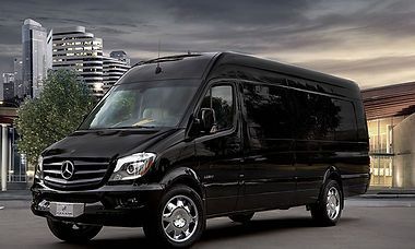 Black Mercedes-Benz Sprinter van parked in front of buildings.