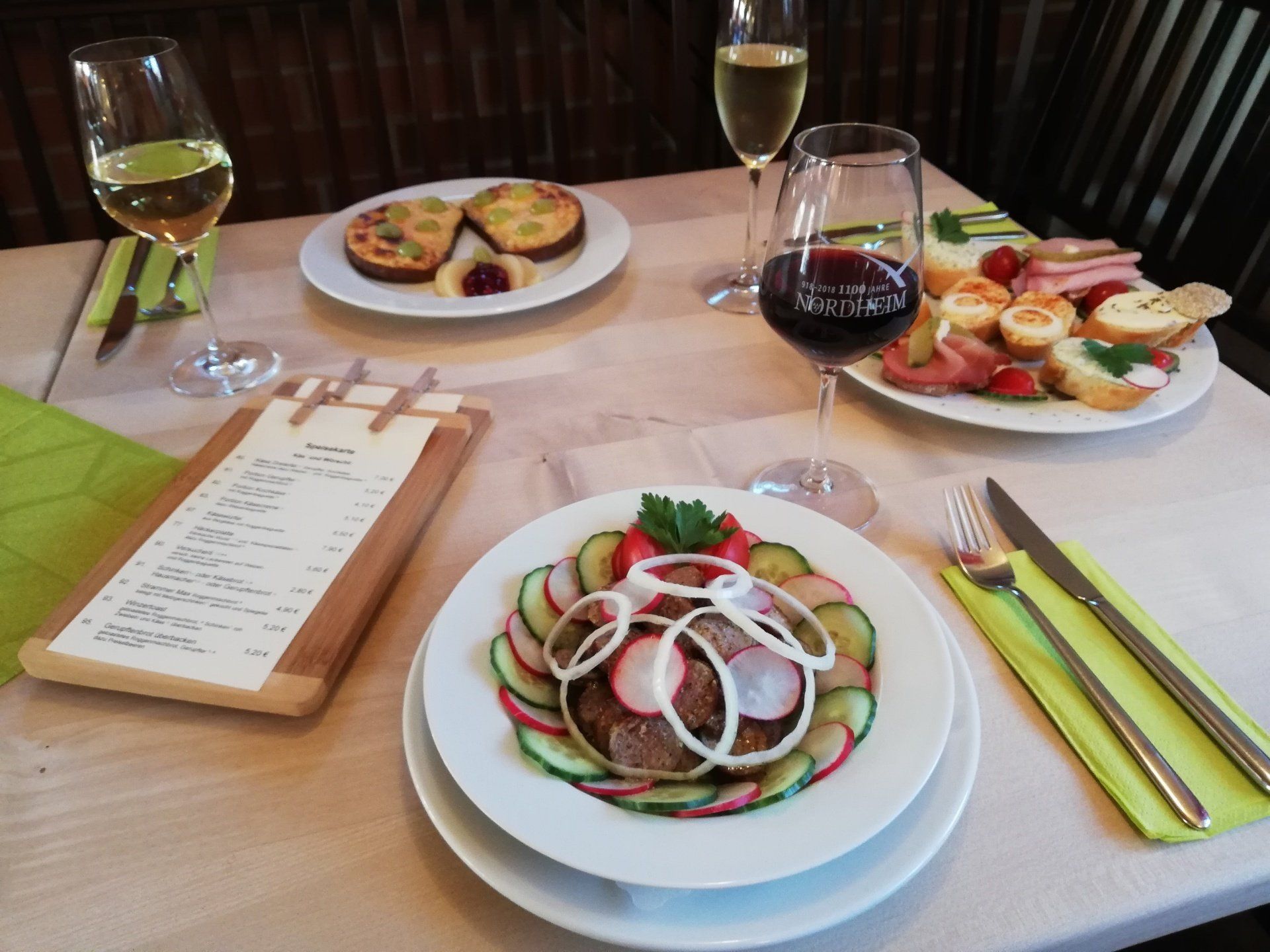 Ein Tisch mit Tellern mit Essen und Gläsern Wein