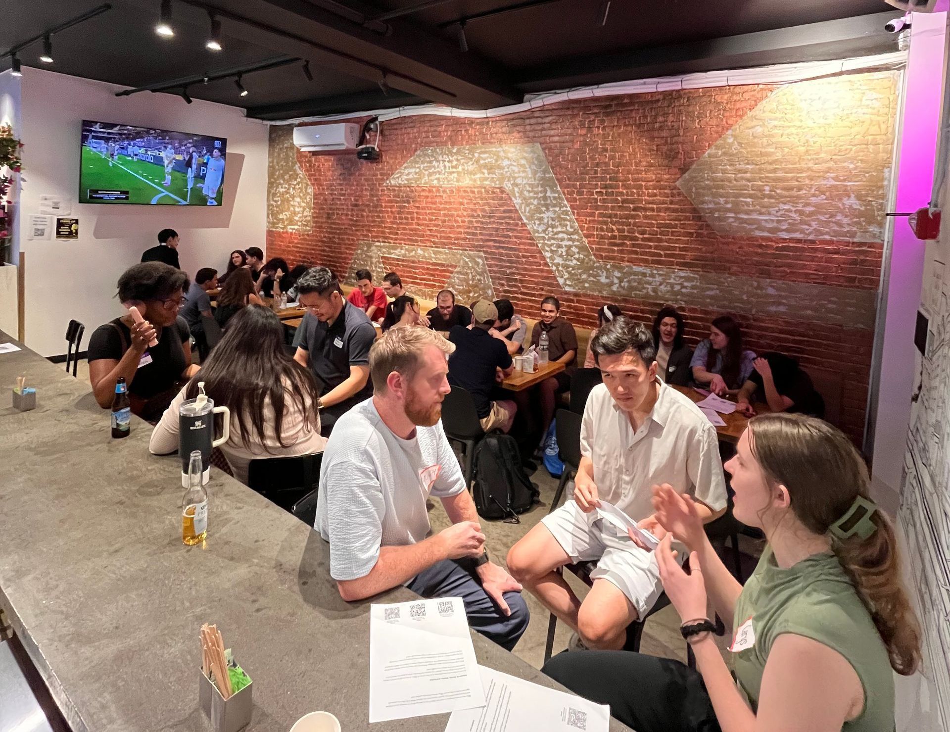 A group of people are sitting at tables in a restaurant.