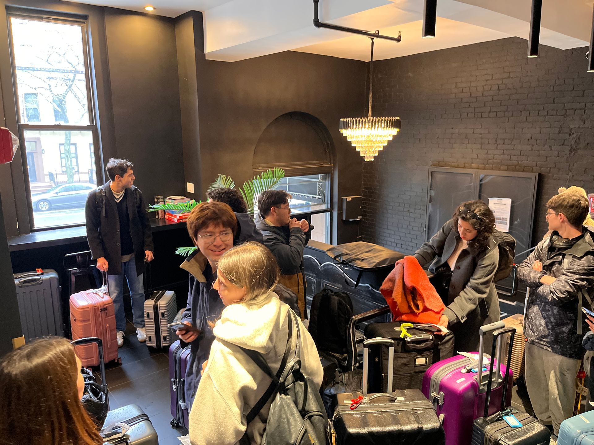 A group of people are standing in a room with luggage.