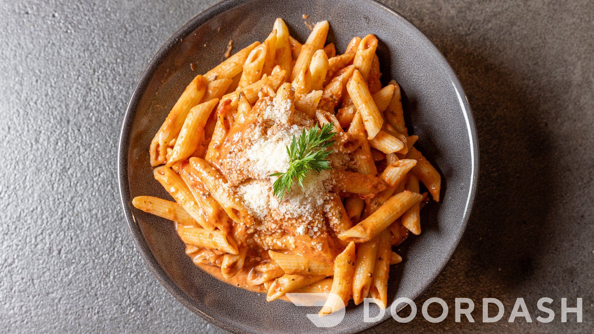 A plate of pasta with sauce and cheese on a table.