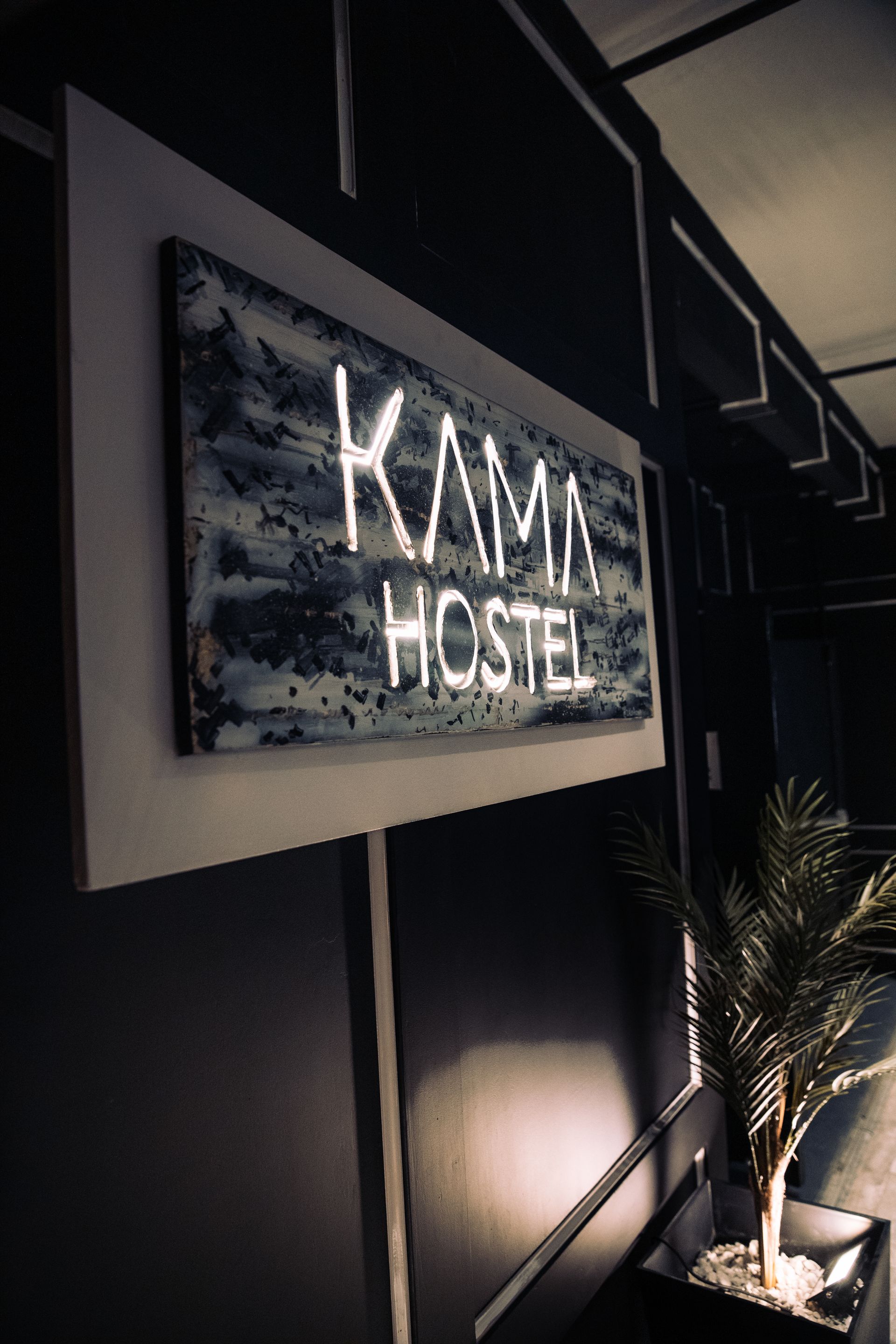 A sign on a wall that says kama hostel