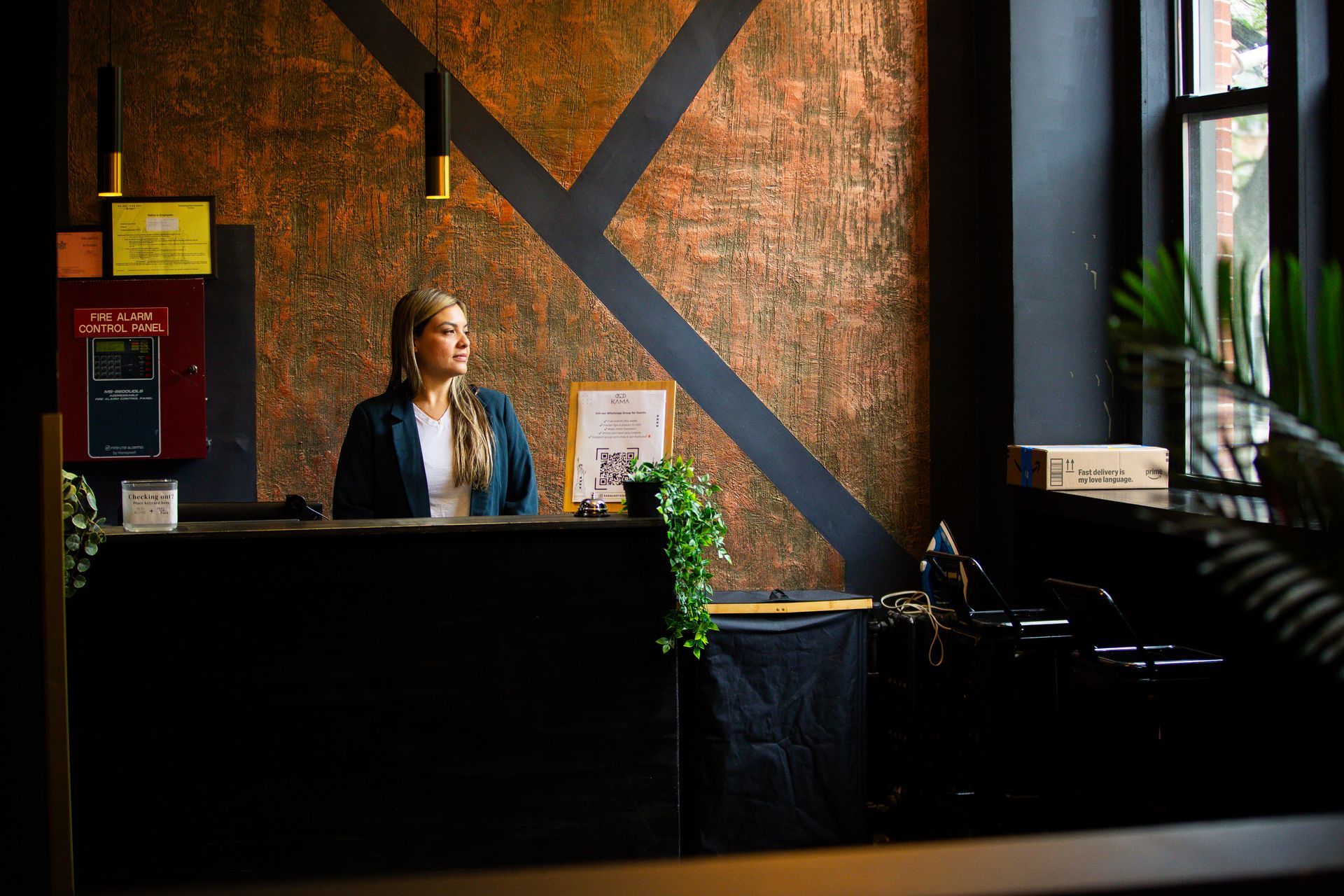 A woman is standing at a reception desk in a restaurant.