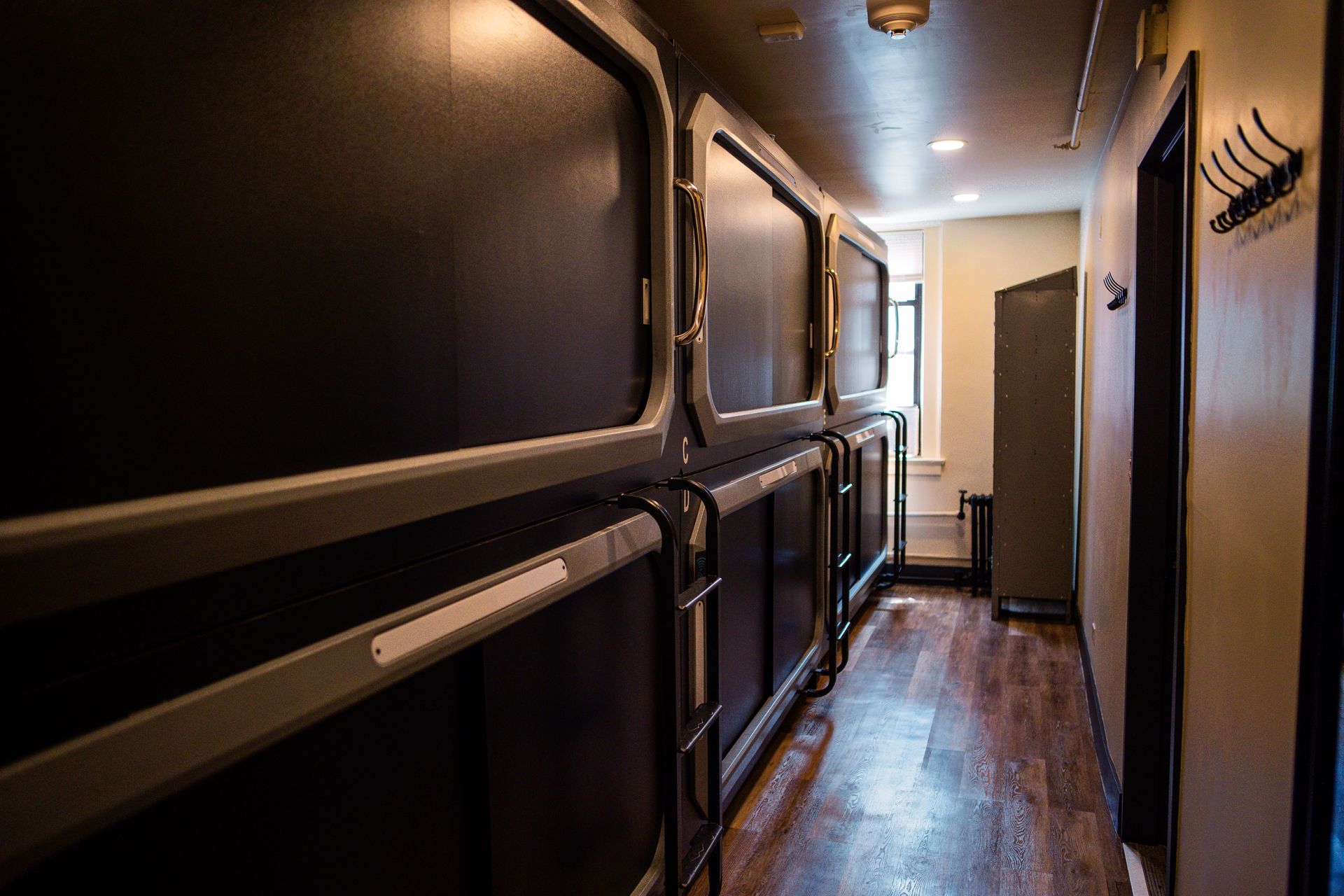 A long hallway with a lot of sleeping pods in it.