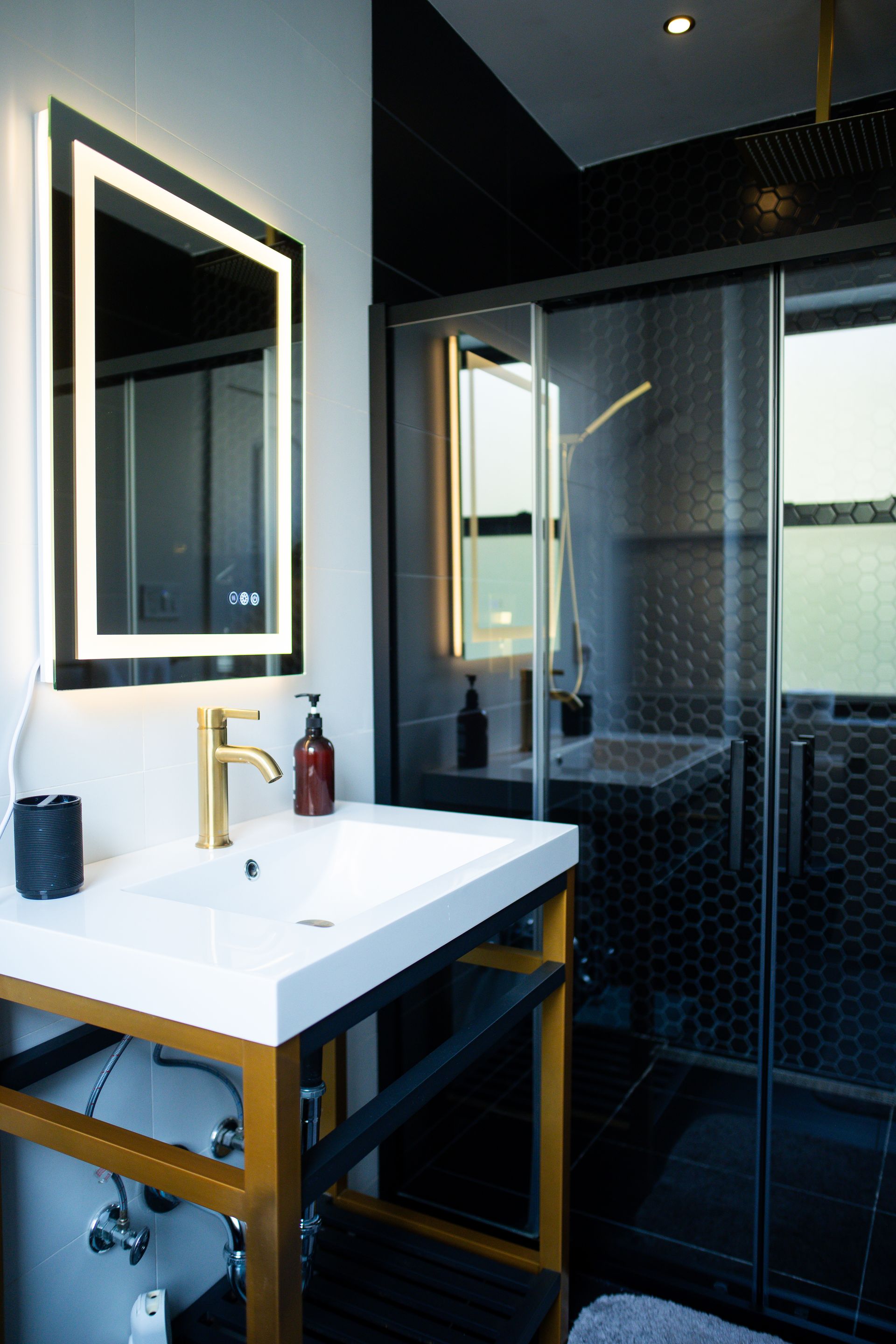 A bathroom with a sink a mirror and a shower