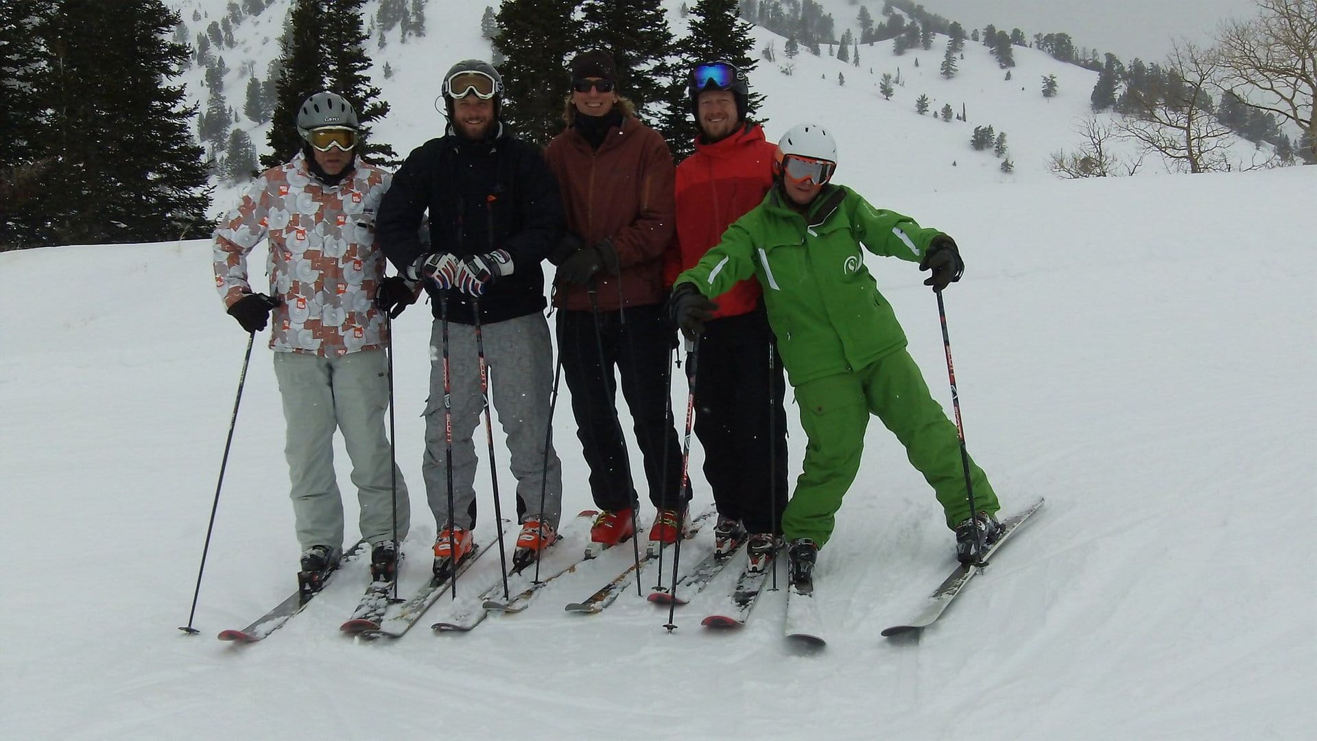 A group of skiers are posing for a picture in the snow
