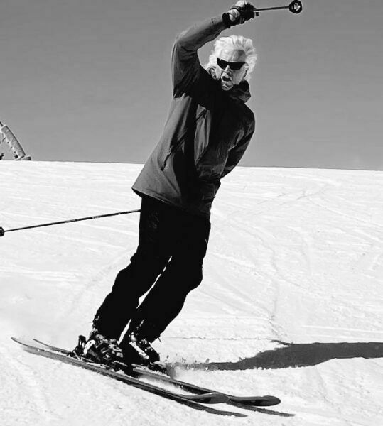 A black and white photo of a man skiing down a snow covered slope