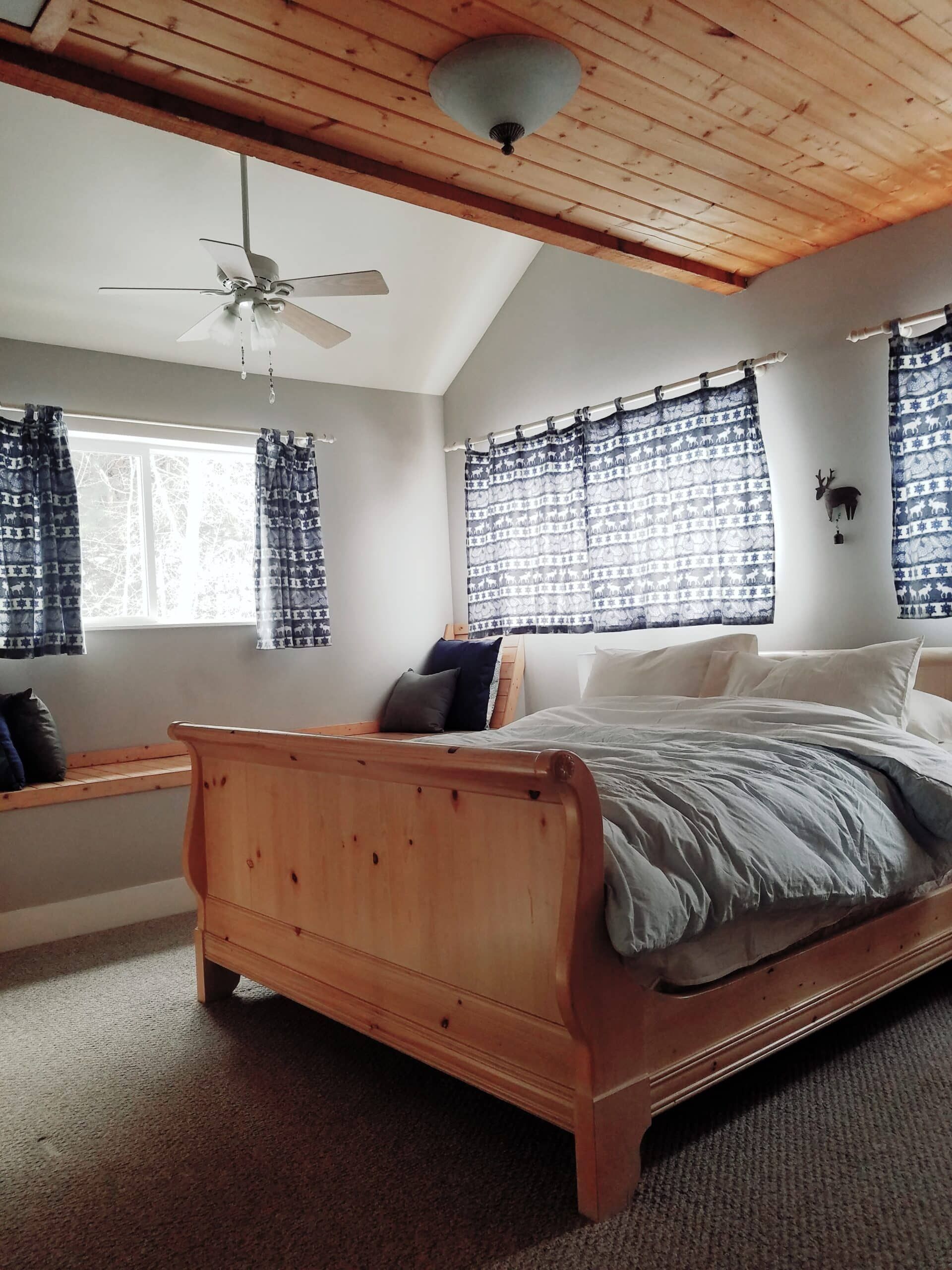 A bedroom with a sleigh bed and a ceiling fan