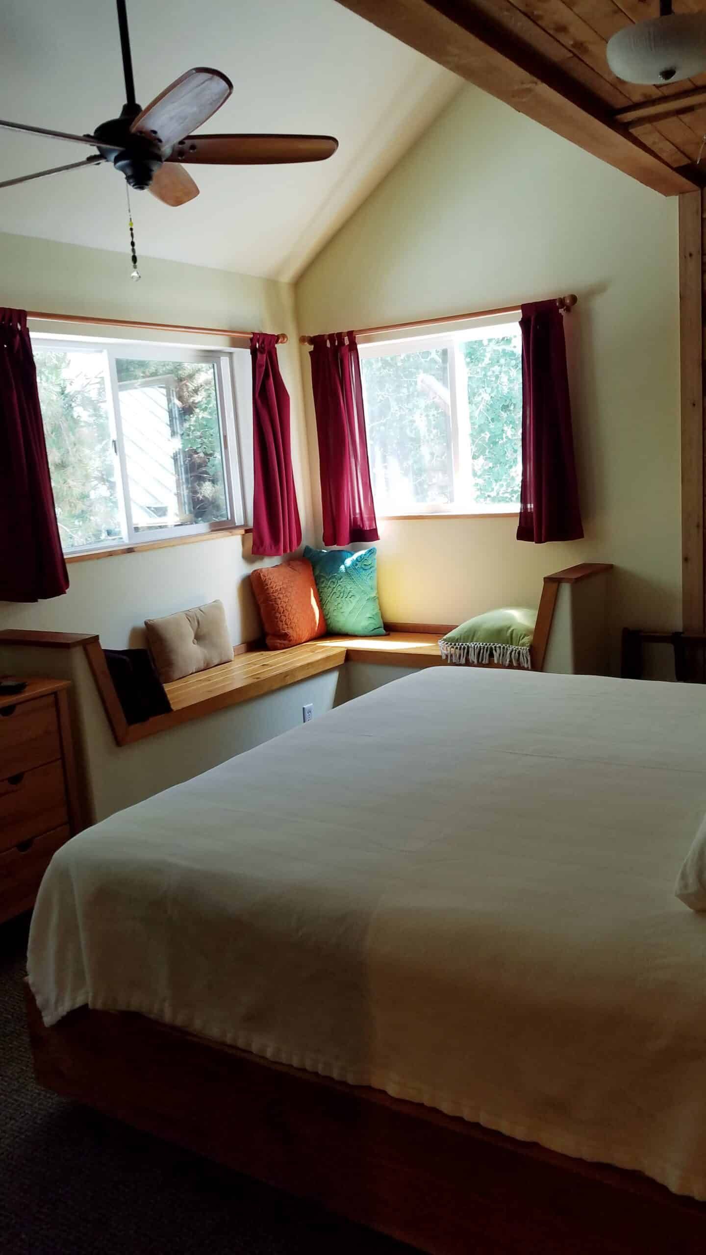 A bedroom with a bed and a ceiling fan