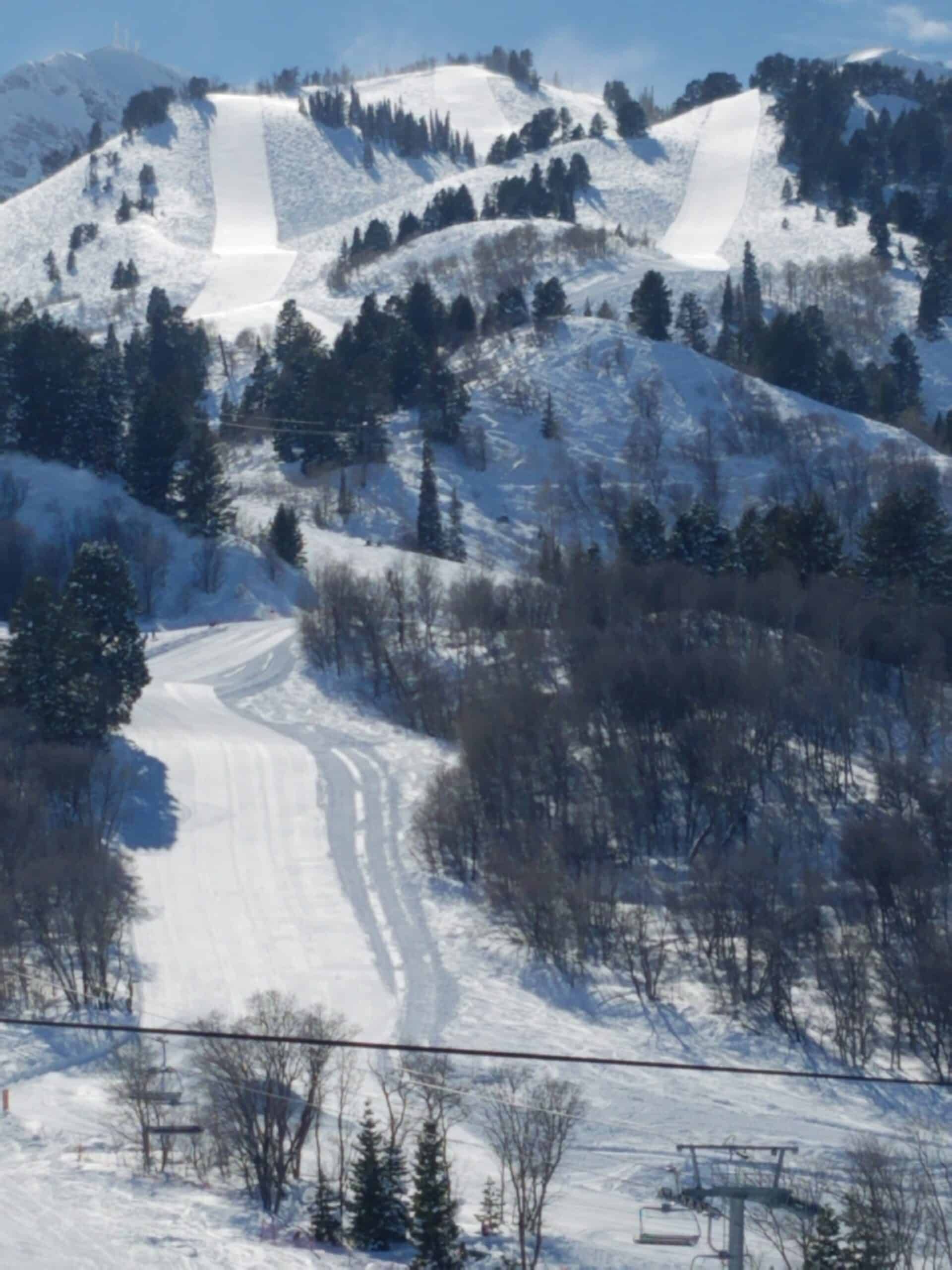 A snowy mountain with a ski lift in the foreground