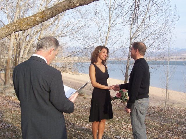 A man is holding a woman 's hand in front of a lake