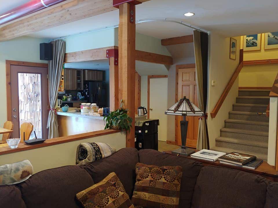 A living room with a couch and stairs and a lamp