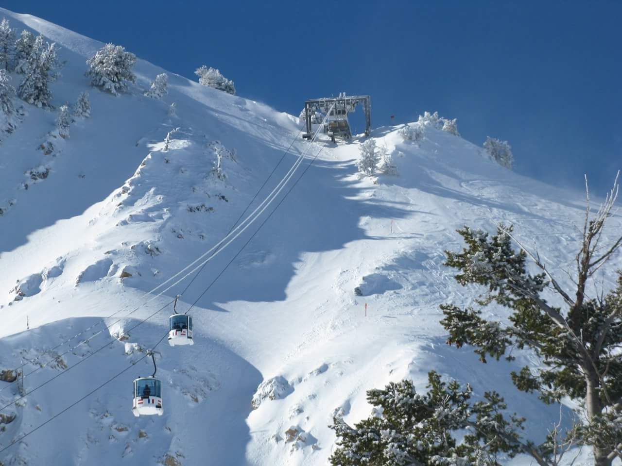 A ski lift going up a snow covered mountain
