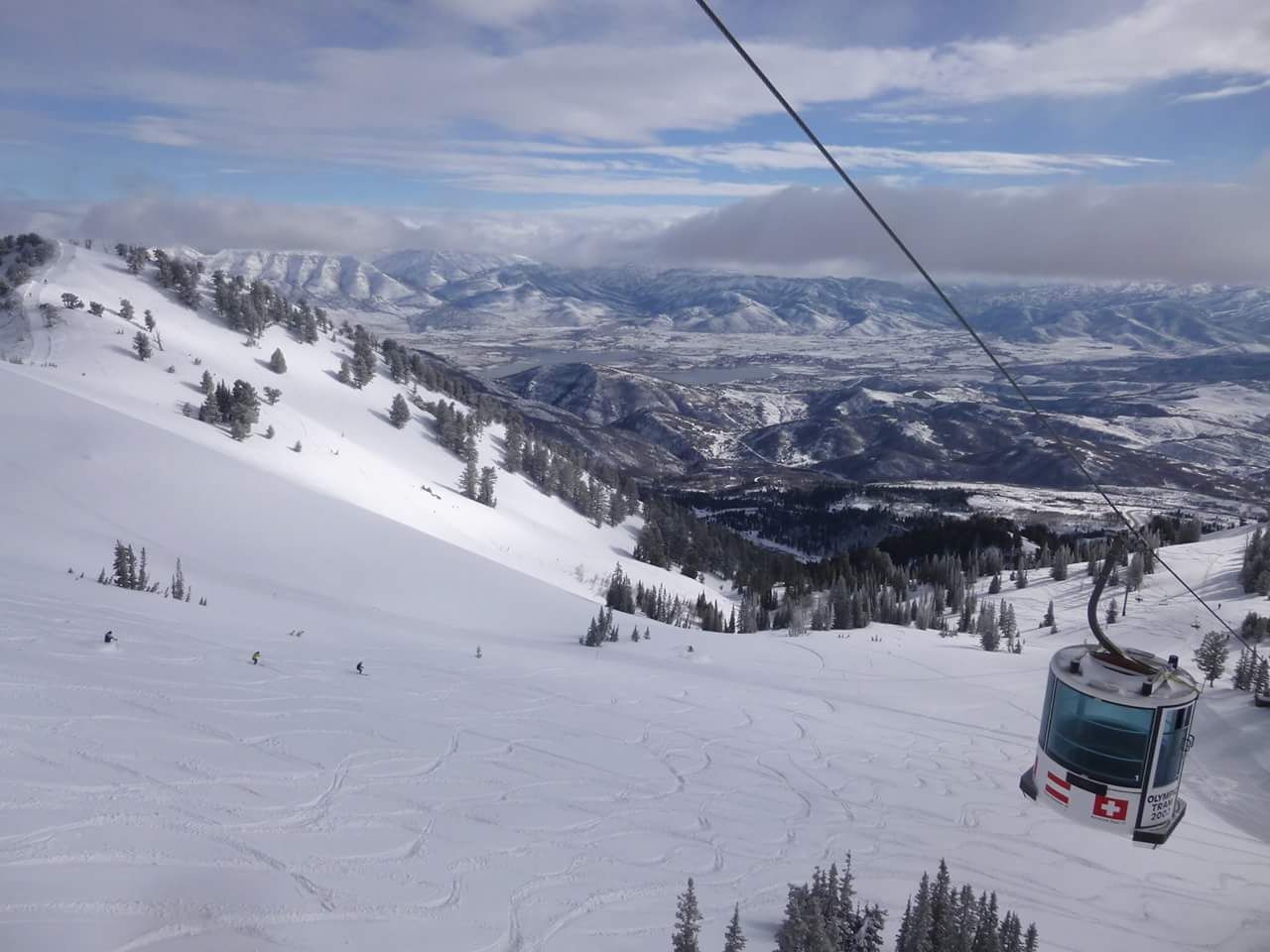 A ski lift going up a snow covered mountain