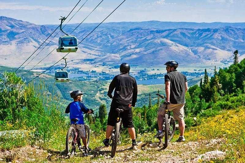 A group of people are riding bikes on a trail in the mountains.