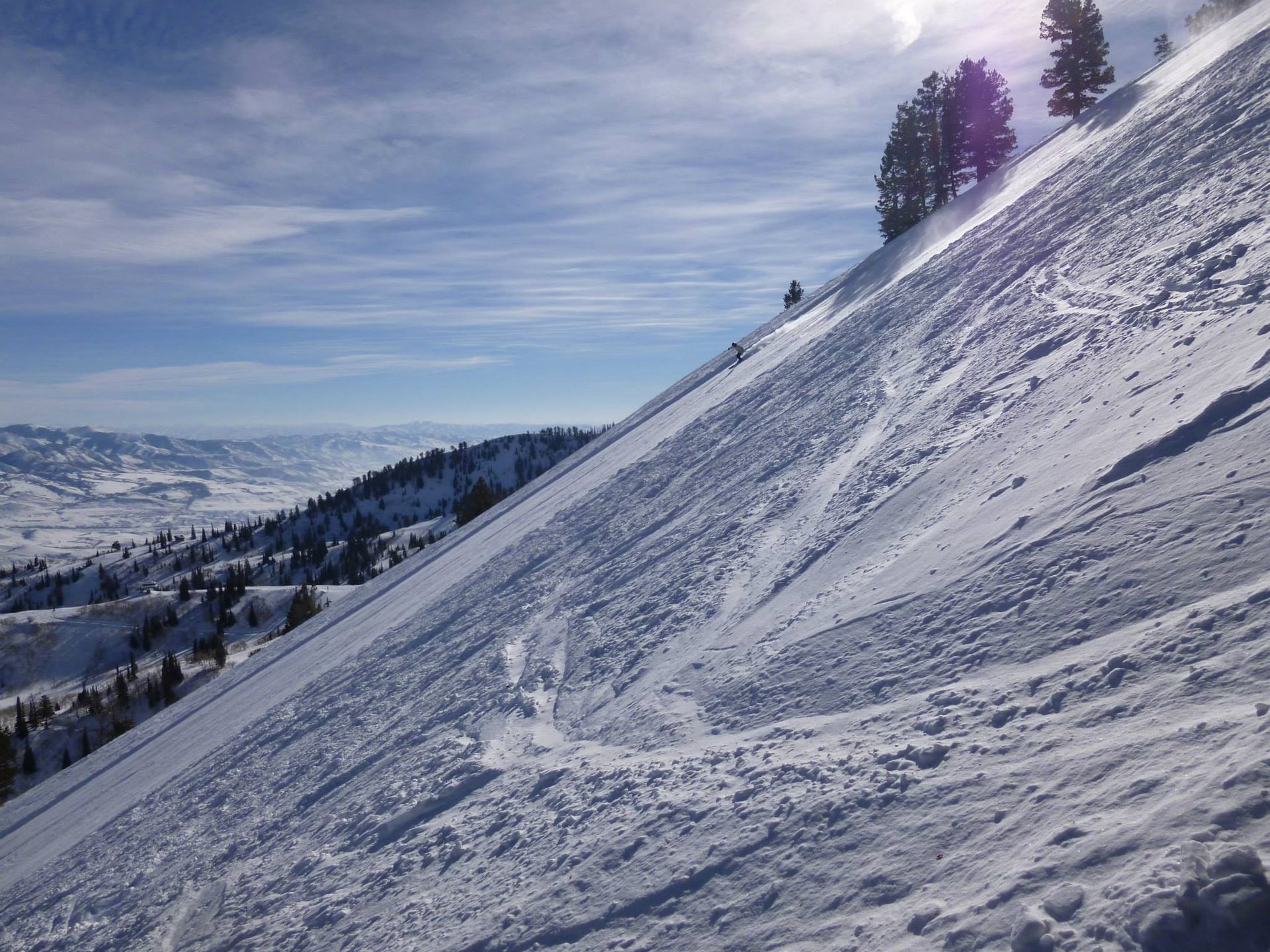 A snowy slope with trees on the side of it