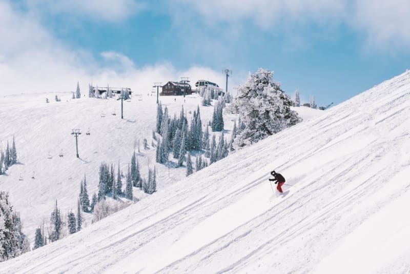 A person is skiing down a snow covered slope.