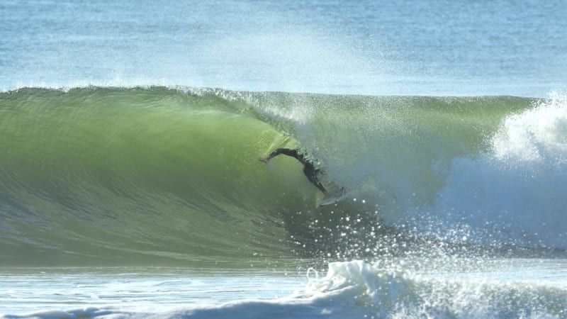 A surfer is riding a wave on a surfboard in the ocean.