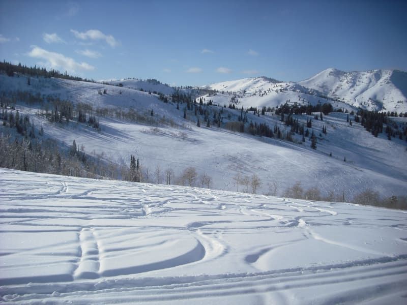 A snowy landscape with mountains in the background