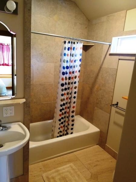 A bathroom with a polka dot shower curtain and a sink