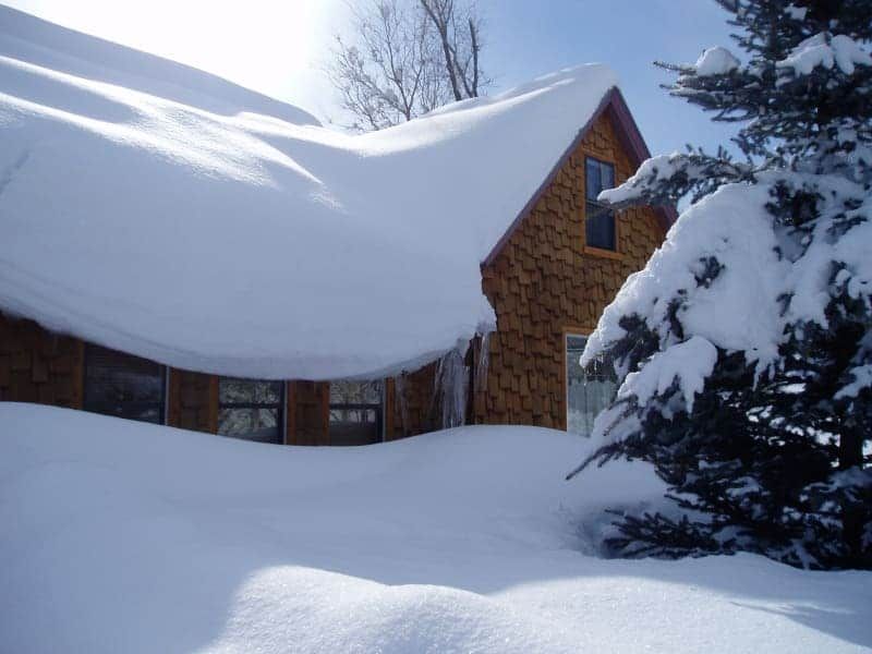 A house with a roof that is covered in snow
