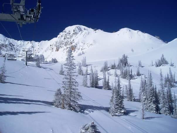 A ski lift going up a snow covered mountain