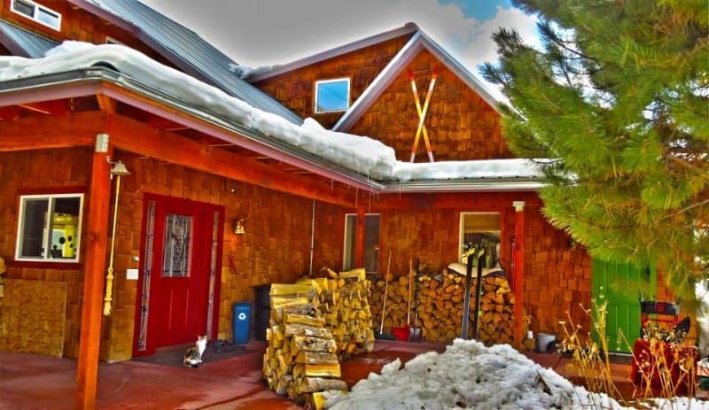 A house with a red door and snow on the roof