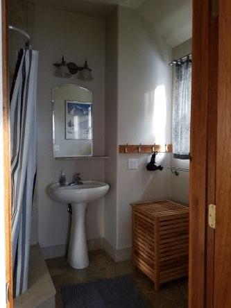 A bathroom with a sink , mirror and shower curtain