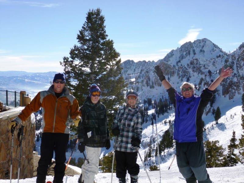 A group of people standing in the snow with their arms in the air