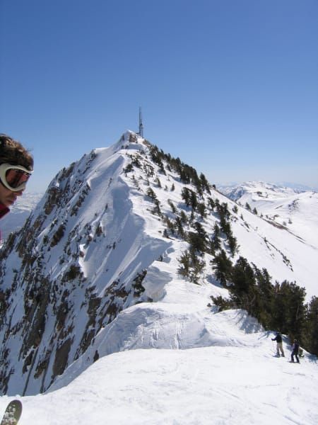 A person standing on top of a snow covered mountain