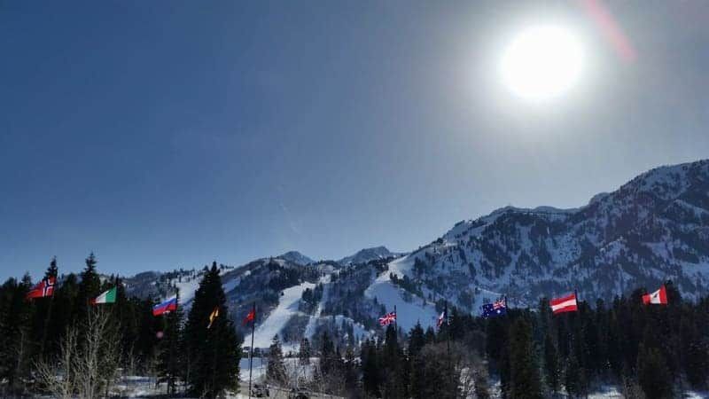 The sun is shining brightly over a snowy mountain range.