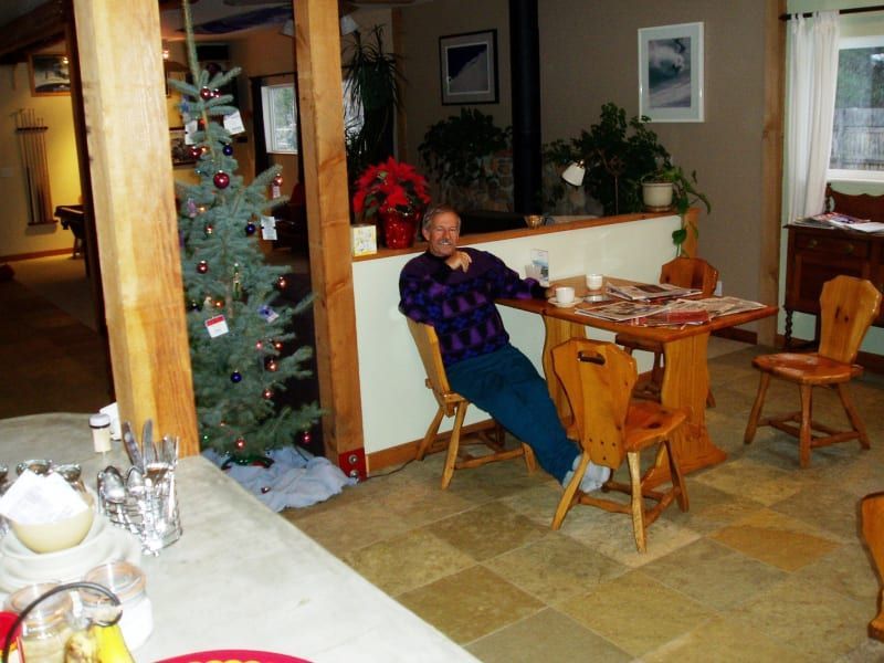 A man sits at a table in front of a christmas tree