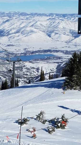 A ski lift is going up a snow covered mountain