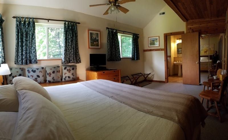 A bedroom with a large bed and a ceiling fan