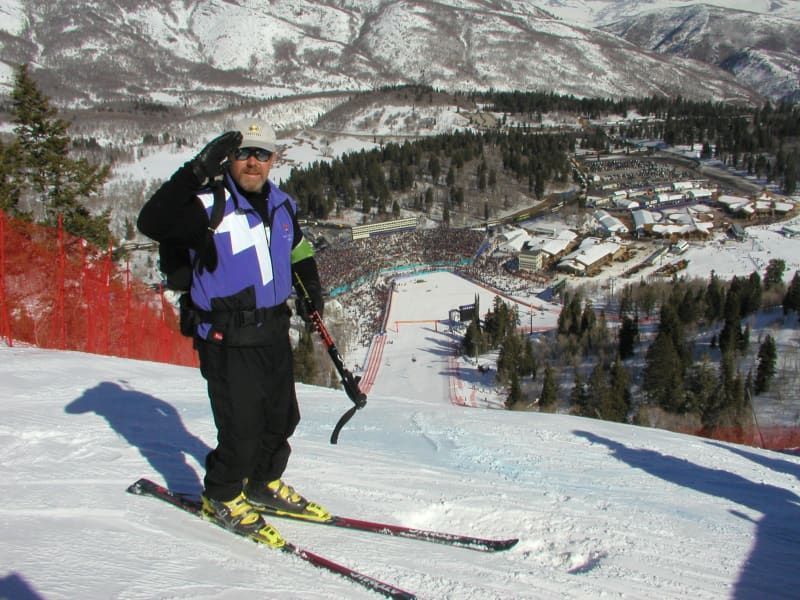 A man is skiing down a snowy slope with the number 11 on his shirt