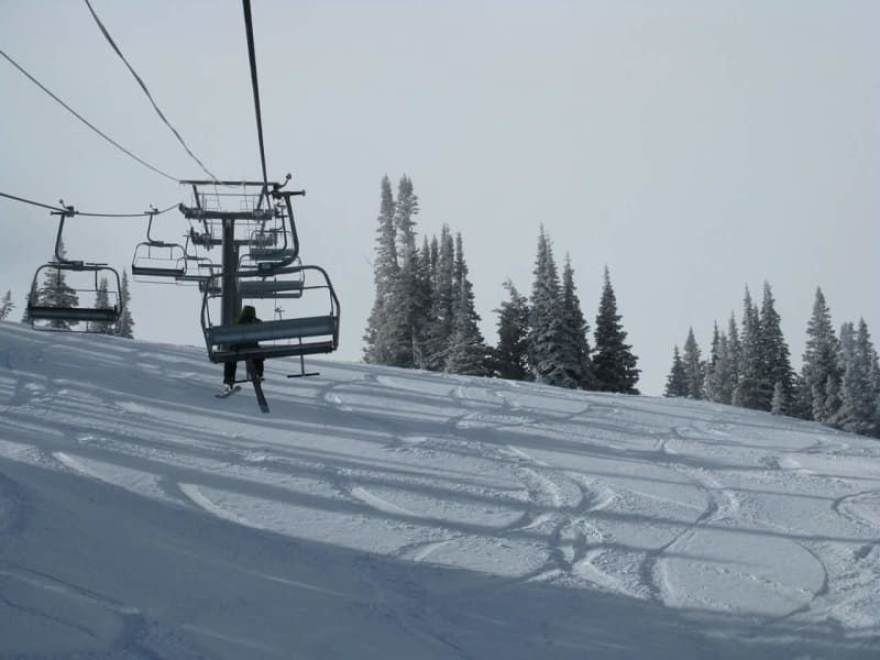 A ski lift going up a snow covered mountain