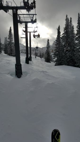 A ski lift is going up a snow covered mountain.