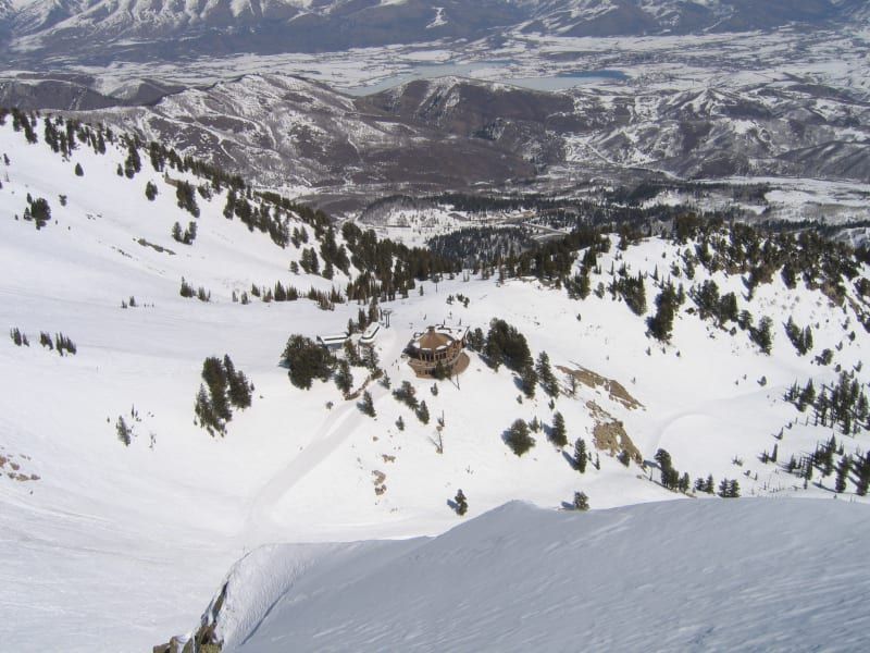 A snowy landscape with trees and mountains in the background