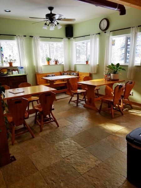 A room with tables and chairs and a clock on the wall