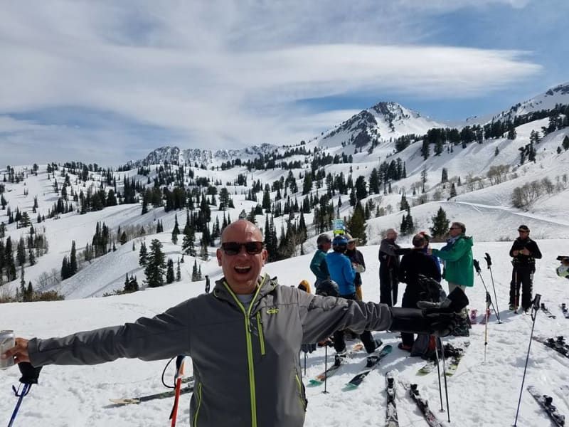 A man is standing in the snow with his arms outstretched