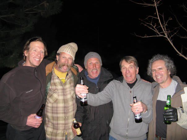 A group of men toasting with beer bottles in their hands