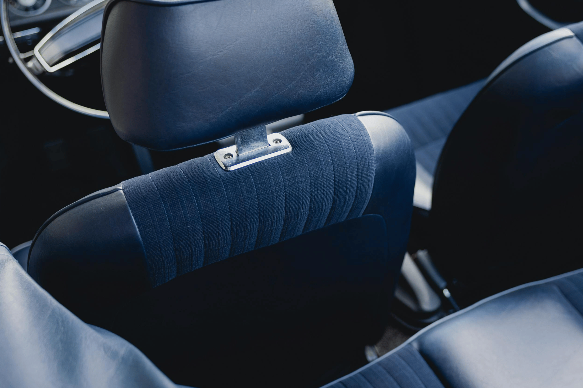 Blue vintage car seat with headrest, interior shot.