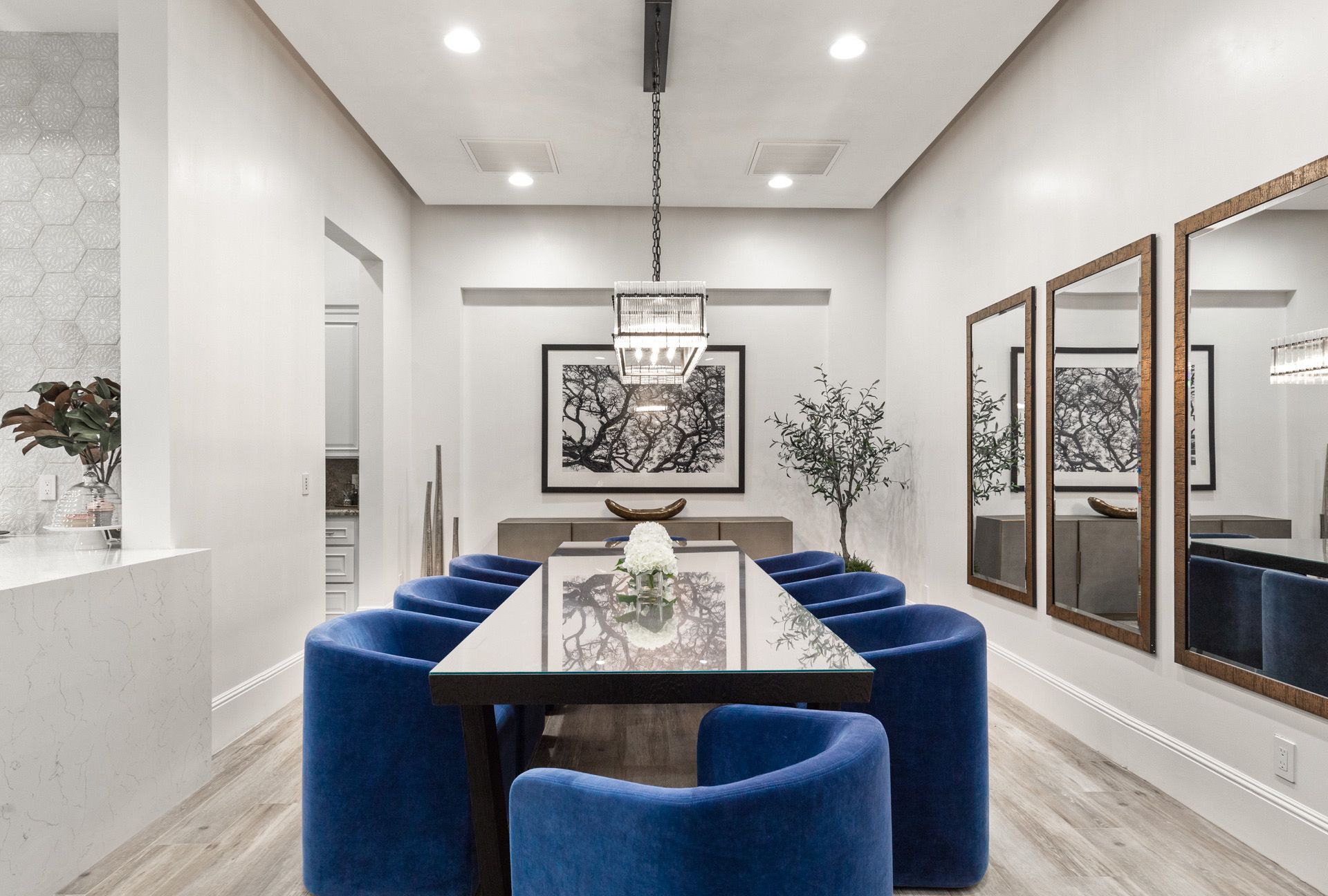 Elegant dining room with a long table, blue chairs, and mirrors.