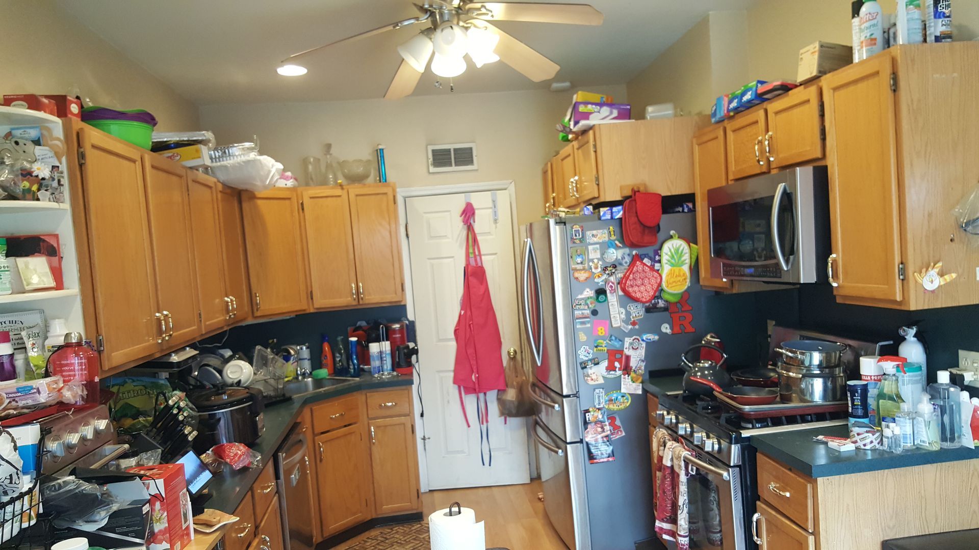 A kitchen with wooden cabinets and a ceiling fan