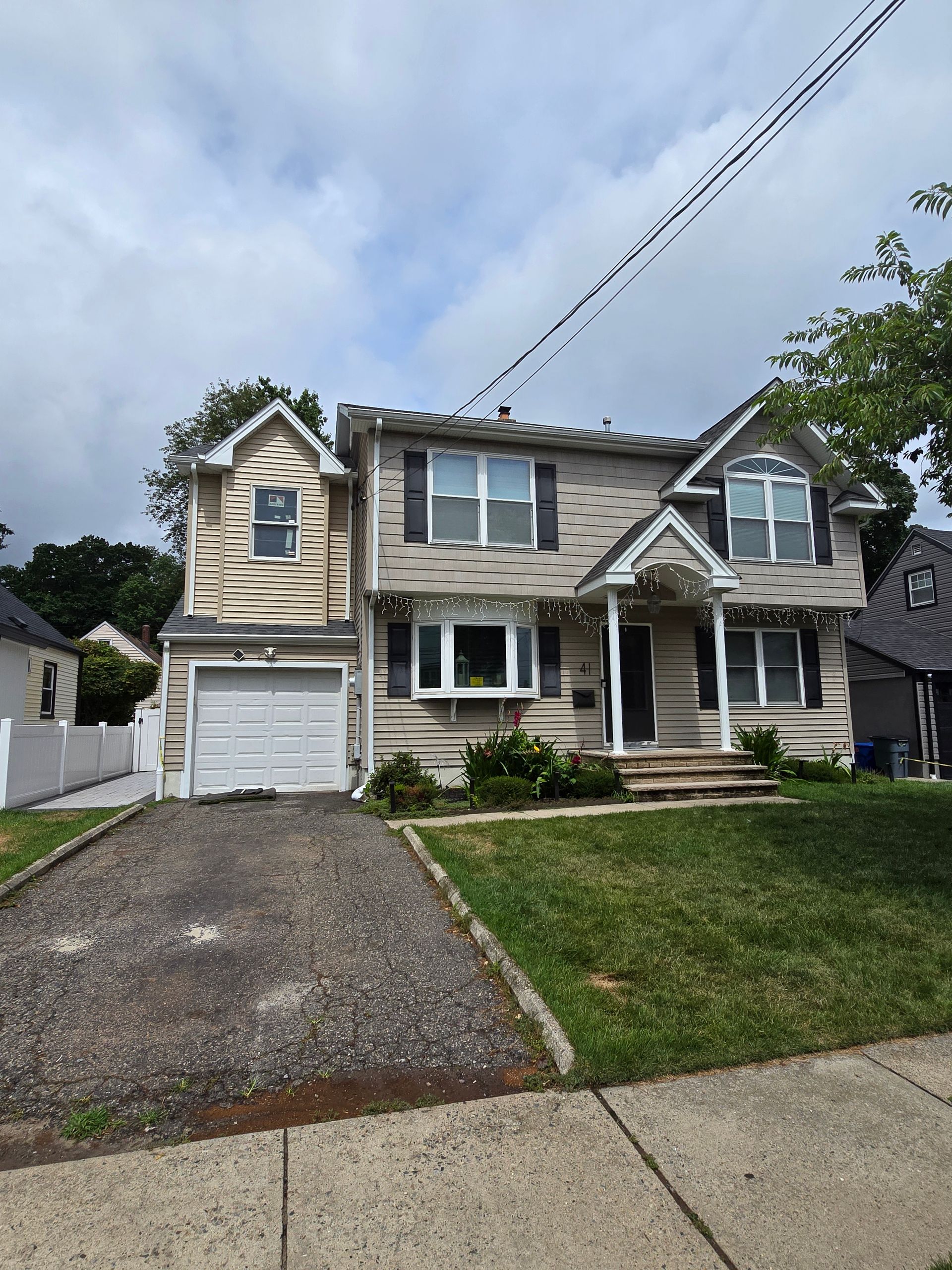 A house with a garage and a driveway in front of it.