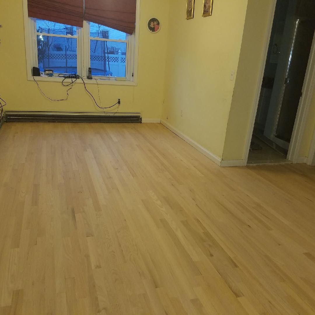 A living room with hardwood floors and a window.