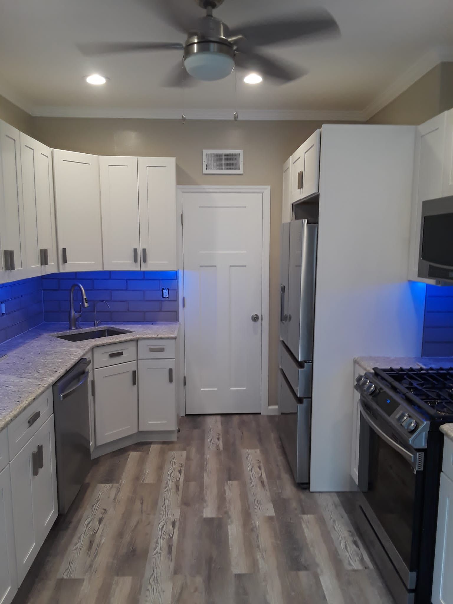 A kitchen with white cabinets and stainless steel appliances